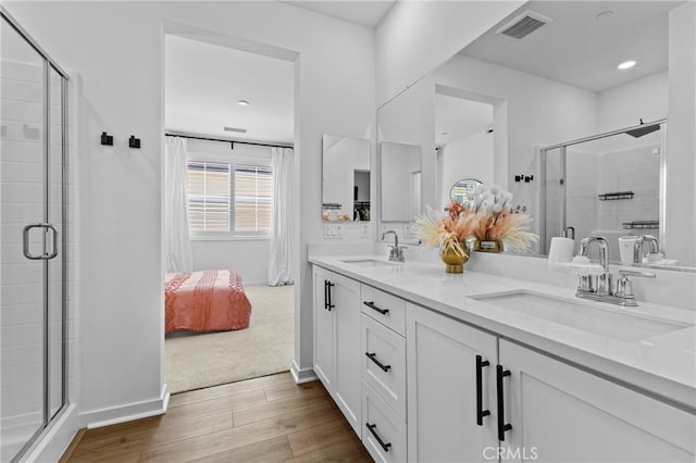 4408 S Grant Paseo, Ontario, CA 91762 - bathroom featuring wood finished floors, double vanity, a stall shower, and ensuite bath