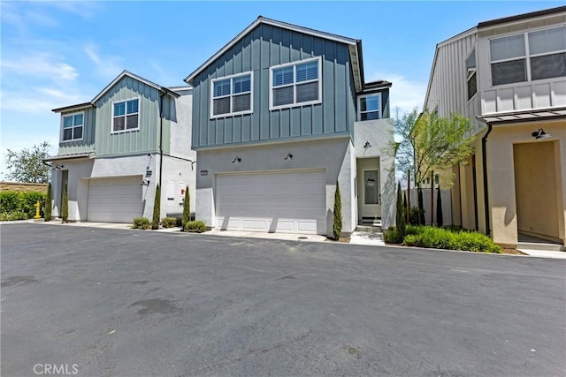 4408 S Grant Paseo, Ontario, CA 91762 - view of front of property featuring board and batten siding, a garage, stucco siding, and asphalt driveway