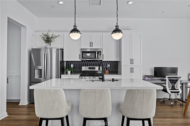 4408 S Grant Paseo, Ontario, CA 91762 - kitchen with stainless steel appliances, a kitchen island with sink, backsplash, a breakfast bar, and white cabinets