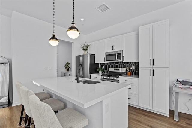 4408 S Grant Paseo, Ontario, CA 91762 - kitchen featuring appliances with stainless steel finishes, an island with sink, a kitchen bar, white cabinetry, and recessed lighting