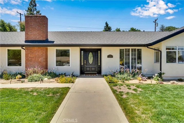 406 Eucalyptus Dr, Redlands, CA 92373 - ranch-style home with a chimney, a front yard, a shingled roof, and stucco siding