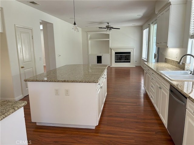 39877 Worthington Pl, Temecula, CA 92591 - kitchen with dishwasher, a ceiling fan, a glass covered fireplace, and dark wood-style floors