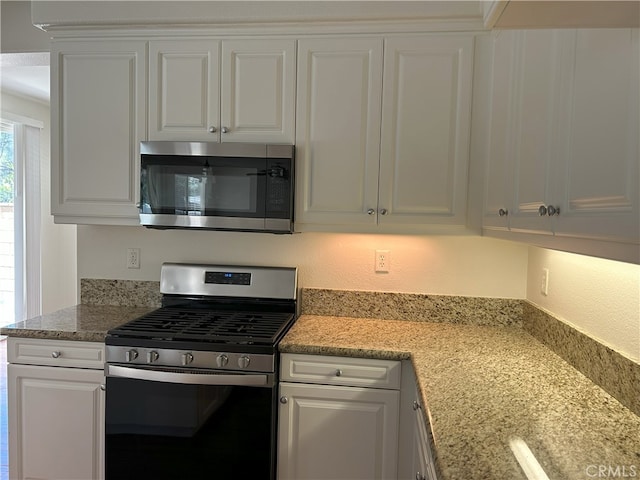 39877 Worthington Pl, Temecula, CA 92591 - kitchen featuring stainless steel appliances, white cabinets, light stone counters, and a textured wall