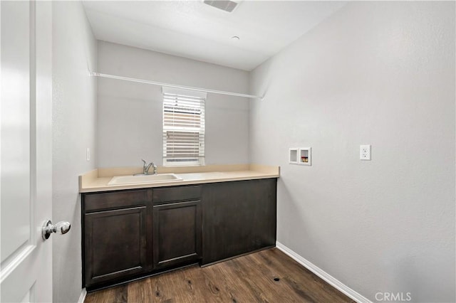 37398 Paseo Violeta Unit 75, Murrieta, CA 92563 - washroom featuring washer hookup, dark wood-type flooring, and cabinet space