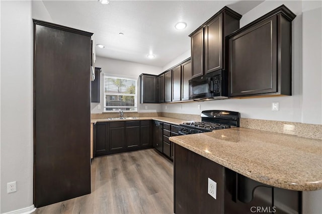 37398 Paseo Violeta Unit 75, Murrieta, CA 92563 - kitchen featuring black appliances, dark brown cabinets, light wood finished floors, light stone countertops, and a peninsula