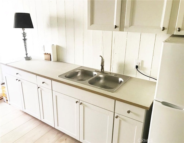 23551 Avenida La Caza Unit 129, Coto De Caza, CA 92679 - kitchen featuring freestanding refrigerator, white cabinets, light countertops, and light wood-style floors
