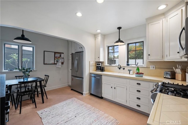 5022 E Broadway, Long Beach, CA 90803 - kitchen with appliances with stainless steel finishes, tile counters, white cabinets, recessed lighting, and arched walkways