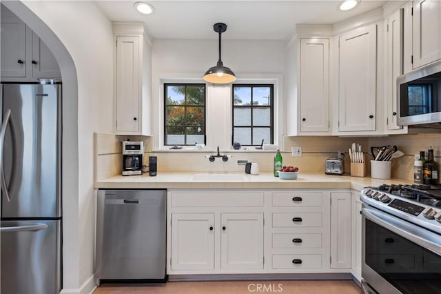 5022 E Broadway, Long Beach, CA 90803 - kitchen featuring appliances with stainless steel finishes, tile counters, white cabinetry, tasteful backsplash, and recessed lighting