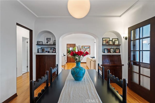 5022 E Broadway, Long Beach, CA 90803 - dining space with light wood-type flooring, arched walkways, built in features, and crown molding