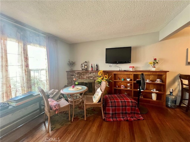 25521 17th St, San Bernardino, CA 92404 - living area with a textured ceiling, wood finished floors, and a fireplace