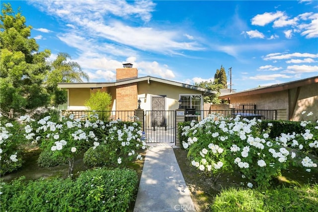 1305 W Beverly Dr, Orange, CA 92868 - view of front of property with stucco siding, a chimney, and a gate
