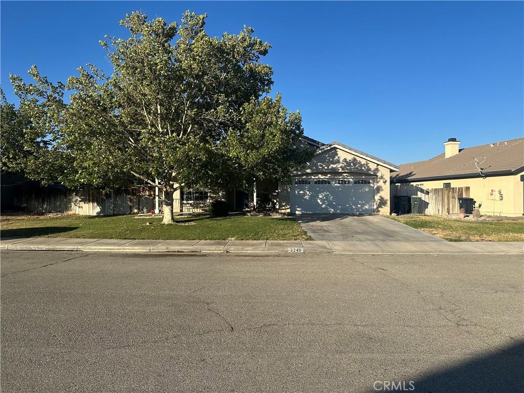 2248 Greenhill St, Rosamond, CA 93560 - view of property hidden behind natural elements with a garage and concrete driveway