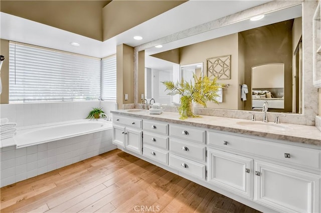 24676 Vista Cerritos, Calabasas, CA 91302 - ensuite bathroom featuring double vanity, a garden tub, and wood finished floors