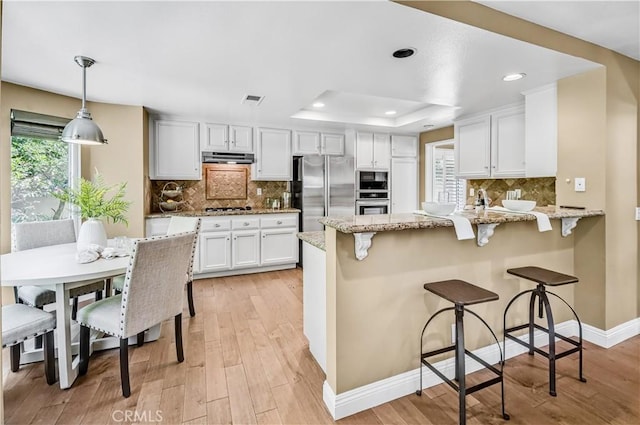 24676 Vista Cerritos, Calabasas, CA 91302 - kitchen with stainless steel appliances, a peninsula, white cabinetry, light wood-style floors, and recessed lighting