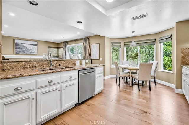 24676 Vista Cerritos, Calabasas, CA 91302 - kitchen with dishwasher, white cabinets, hanging light fixtures, light wood-style flooring, and light stone counters