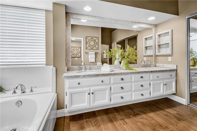 24676 Vista Cerritos, Calabasas, CA 91302 - bathroom with double vanity, a garden tub, and wood finished floors