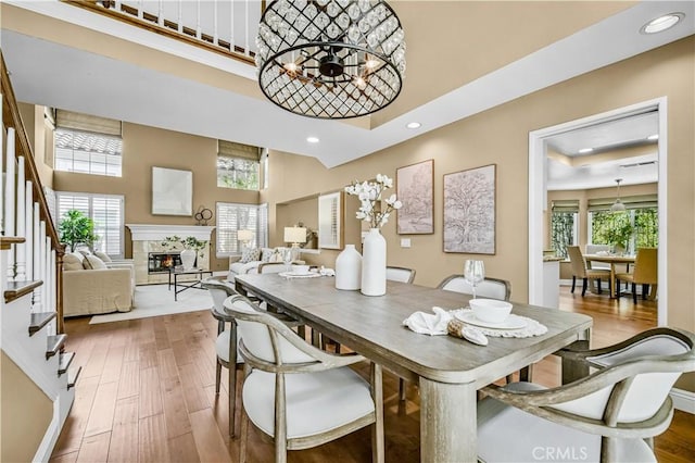 24676 Vista Cerritos, Calabasas, CA 91302 - dining area with a towering ceiling, recessed lighting, a chandelier, wood finished floors, and a fireplace