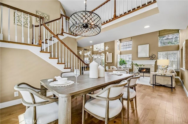 24676 Vista Cerritos, Calabasas, CA 91302 - dining room with a high ceiling, hardwood / wood-style flooring, a glass covered fireplace, stairs, and a chandelier