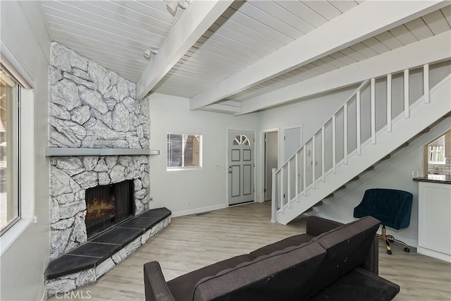 776 Lords Ln, Lake Arrowhead, CA 92352 - living area featuring wood finished floors, stairs, beamed ceiling, a stone fireplace, and plenty of natural light
