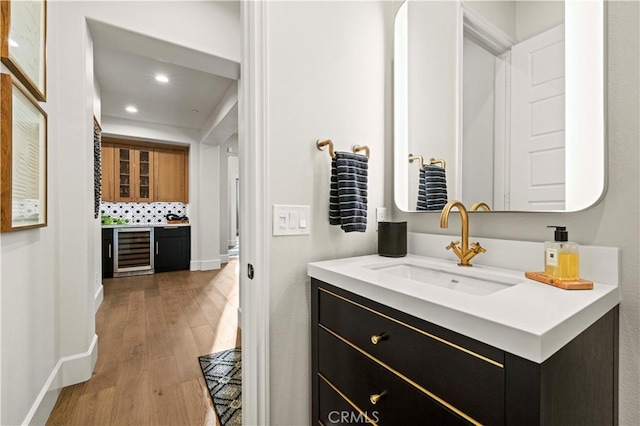 22388 Riverstream Ct, Saugus, CA 91350 - bathroom featuring beverage cooler, vanity, wood finished floors, recessed lighting, and decorative backsplash