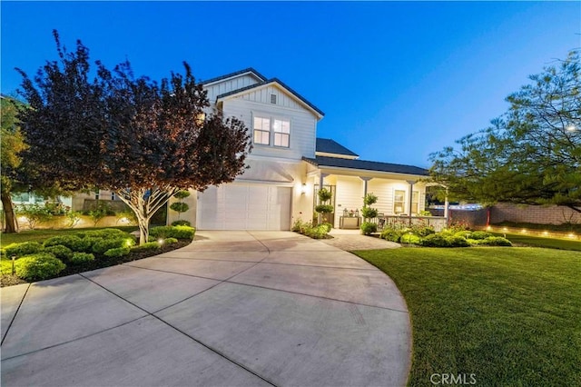 22388 Riverstream Ct, Saugus, CA 91350 - view of front of house featuring concrete driveway, a front lawn, an attached garage, board and batten siding, and covered porch
