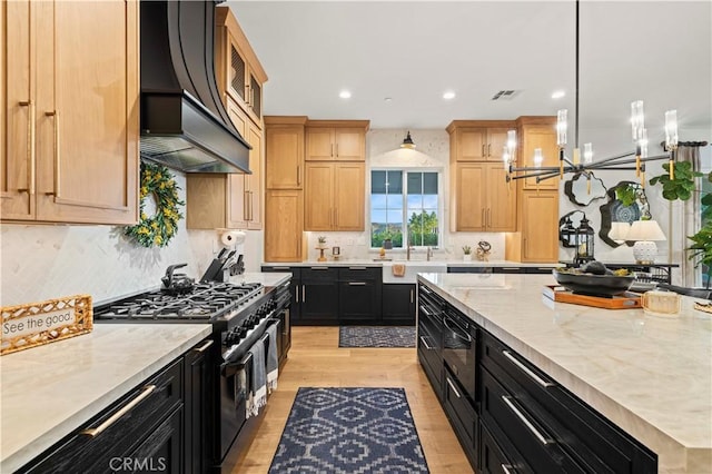 22388 Riverstream Ct, Saugus, CA 91350 - kitchen with range with two ovens, dark cabinets, custom exhaust hood, light wood-style floors, and recessed lighting