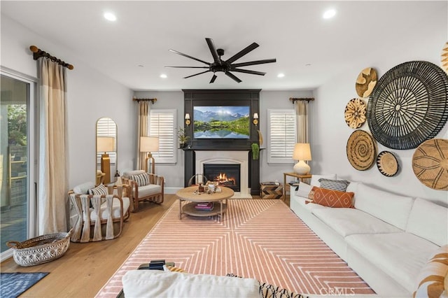 22388 Riverstream Ct, Saugus, CA 91350 - living room with ceiling fan, recessed lighting, a glass covered fireplace, and wood finished floors