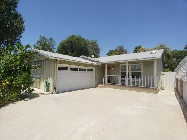 22727 Mariano St, Woodland Hills, CA 91367 - ranch-style home with board and batten siding, covered porch, a garage, and driveway