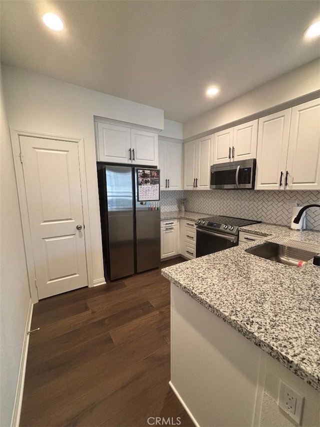 2717 Juniper Berry St, Spring Valley, CA 91977 - kitchen with appliances with stainless steel finishes, white cabinets, light stone countertops, dark wood finished floors, and recessed lighting