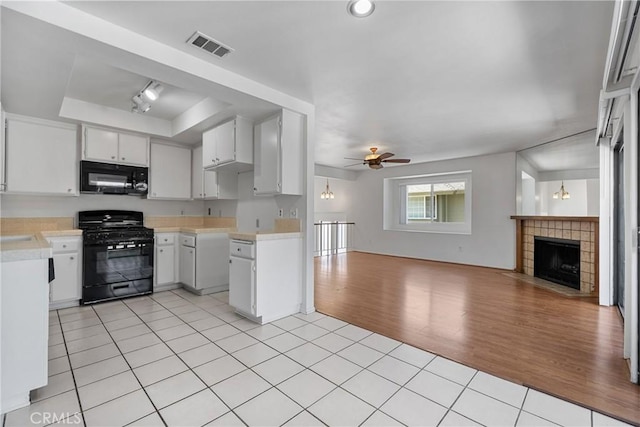 2231 Pacific Ave Unit 14, Costa Mesa, CA 92627 - kitchen with black appliances, open floor plan, light tile patterned floors, and light countertops