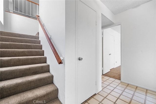 2231 Pacific Ave Unit 14, Costa Mesa, CA 92627 - stairway featuring carpet floors, a textured ceiling, and tile patterned floors