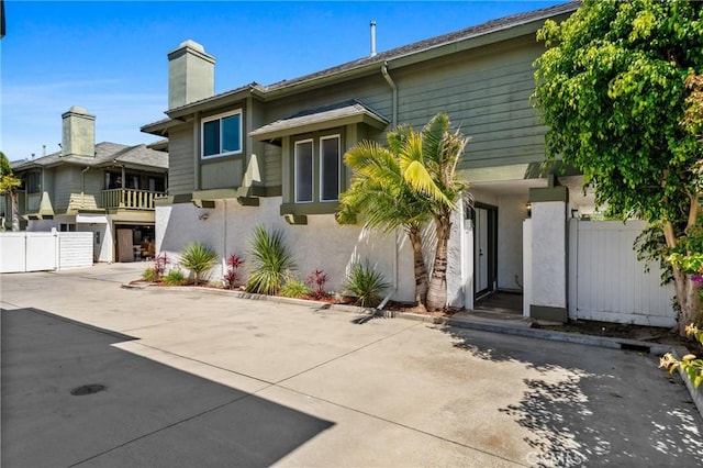 2231 Pacific Ave Unit 14, Costa Mesa, CA 92627 - view of front facade featuring stucco siding and a chimney