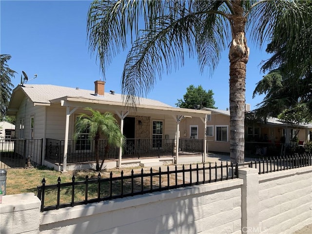 1271 N K St, San Bernardino, CA 92411 - view of front facade with a fenced front yard and a chimney