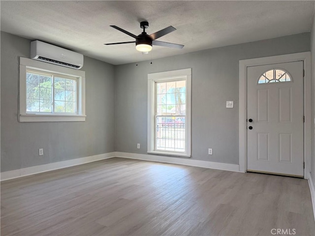 1271 N K St, San Bernardino, CA 92411 - entryway featuring an AC wall unit, light wood-type flooring, plenty of natural light, ceiling fan, and a textured ceiling
