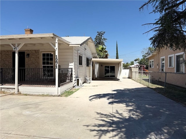 1271 N K St, San Bernardino, CA 92411 - view of side of home with driveway, a chimney, an attached carport, and a porch