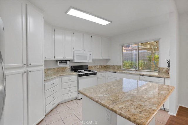 14183 Gale Dr, Victorville, CA 92394 - kitchen featuring white appliances, white cabinets, a center island, and light tile patterned flooring
