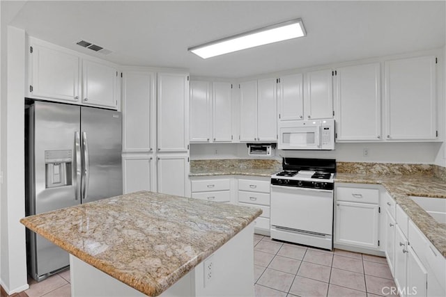 14183 Gale Dr, Victorville, CA 92394 - kitchen with white appliances, light tile patterned flooring, white cabinets, and light stone counters