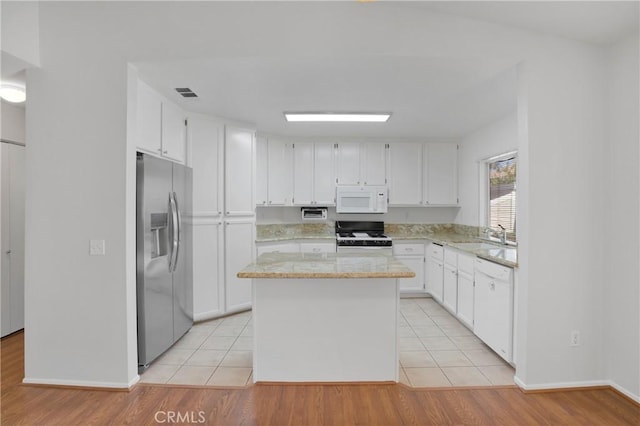 14183 Gale Dr, Victorville, CA 92394 - kitchen featuring white appliances, white cabinets, light stone countertops, and a kitchen island