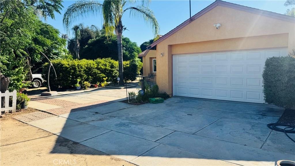 31191 Murrieta Rd, Menifee, CA 92584 - view of property exterior featuring stucco siding, a garage, and driveway