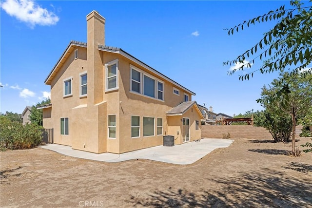 3020 Peaceful Way, Lancaster, CA 93535 - rear view of property featuring stucco siding, a patio, and a chimney