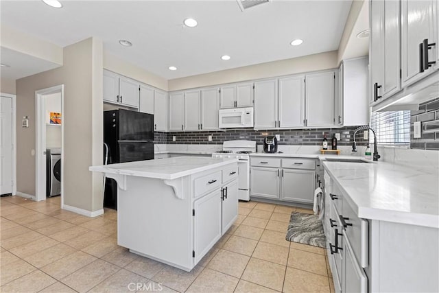3020 Peaceful Way, Lancaster, CA 93535 - kitchen with white appliances, washer / dryer, backsplash, a center island, and recessed lighting