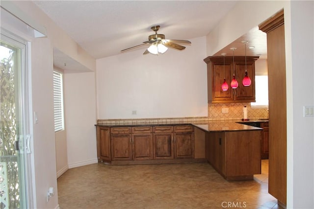 10768 William Ave, Bloomington, CA 92316 - kitchen featuring brown cabinetry, a peninsula, ceiling fan, decorative backsplash, and plenty of natural light