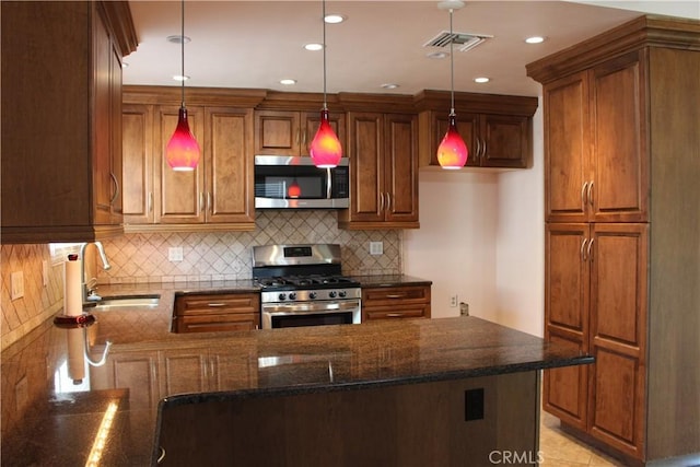 10768 William Ave, Bloomington, CA 92316 - kitchen with stainless steel appliances, brown cabinetry, dark stone countertops, a peninsula, and decorative light fixtures