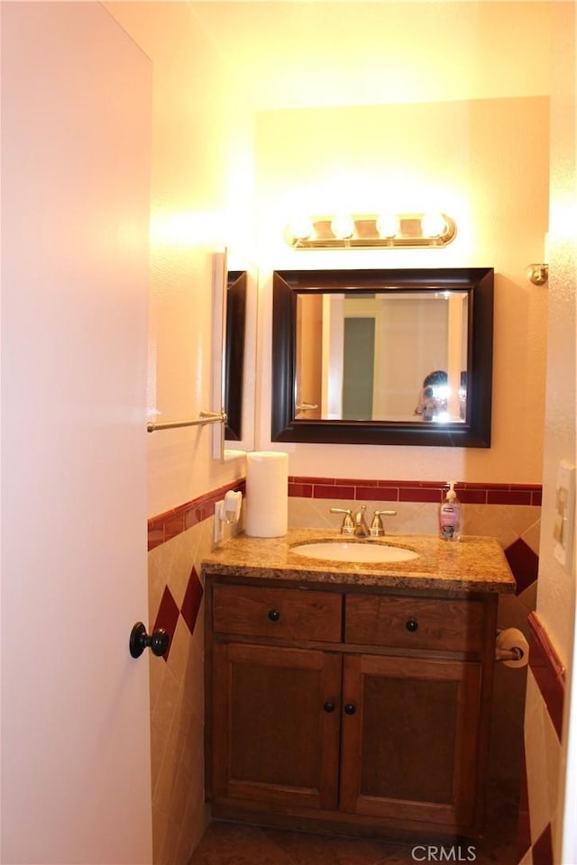 10768 William Ave, Bloomington, CA 92316 - half bathroom featuring tile walls, vanity, and a wainscoted wall