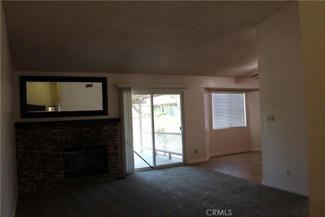 10768 William Ave, Bloomington, CA 92316 - unfurnished living room featuring carpet floors, a brick fireplace, tile patterned flooring, and a textured ceiling