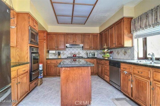 373 Rainbow Ter, Palmdale, CA 93551 - kitchen with appliances with stainless steel finishes, a kitchen island, a warming drawer, under cabinet range hood, and decorative backsplash
