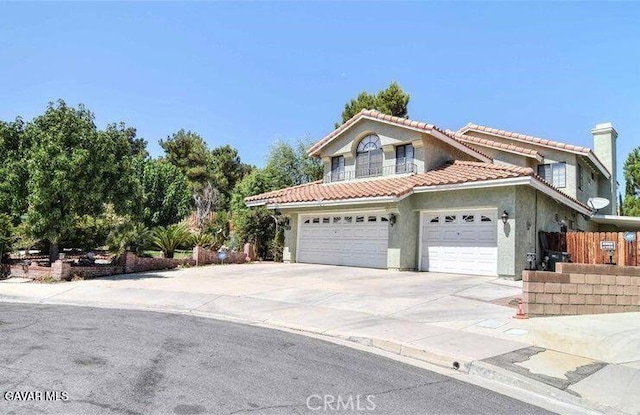 373 Rainbow Ter, Palmdale, CA 93551 - view of front facade featuring stucco siding, a tile roof, concrete driveway, and a chimney