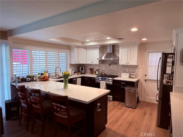 12314 Edgefield St, Cerritos, CA 90703 - kitchen featuring wall chimney range hood, appliances with stainless steel finishes, light countertops, white cabinets, and recessed lighting