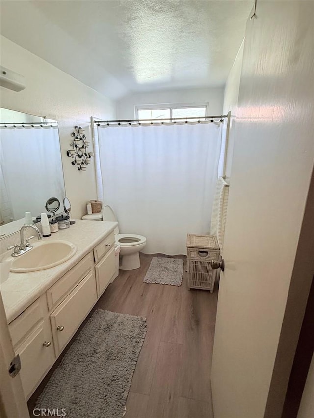 12314 Edgefield St, Cerritos, CA 90703 - full bathroom with vanity, wood finished floors, vaulted ceiling, a shower with shower curtain, and a textured ceiling