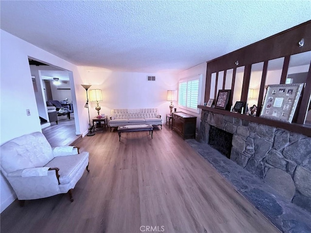 12314 Edgefield St, Cerritos, CA 90703 - living area with wood finished floors, a textured ceiling, and a fireplace with raised hearth